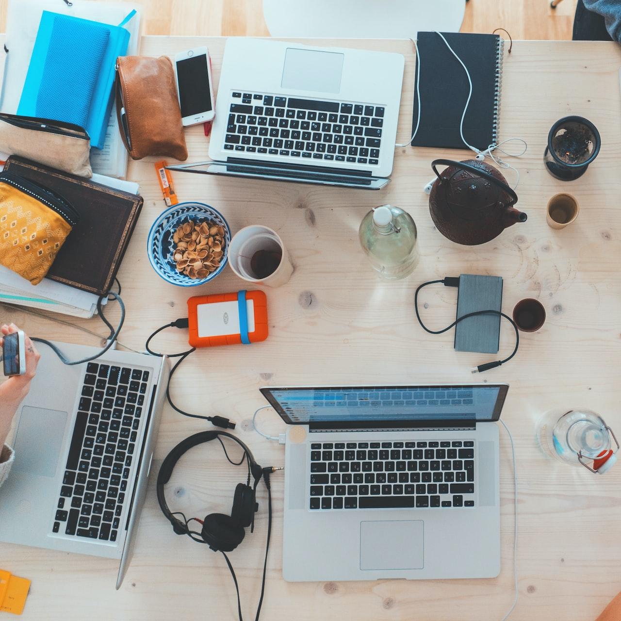 people sitting down near table with assorted laptop computers